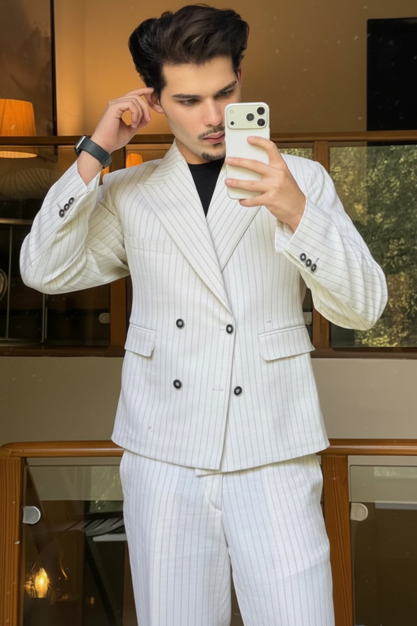 Man taking a mirror selfie wearing a white pinstripe suit.